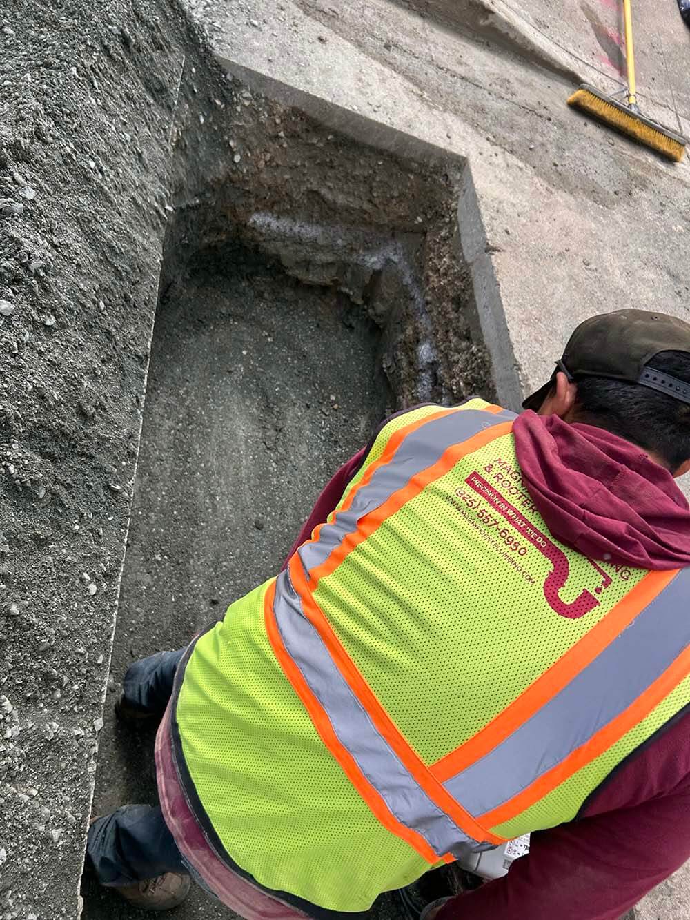 Magnificent Plumbing technician in a company vest repairing an underground line